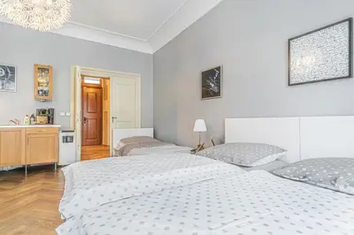 a bedroom with two beds and a sink at Karmelitska 2 luxury 1B apartment in Prague