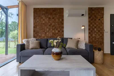 a living room with a couch and a table at Moderní chata se zastřešenou terasou v docházkové vzdálenosti na pláž in Nalžovické Podhájí