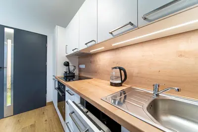 a kitchen with a sink and a wooden counter top at Moderní chata se zastřešenou terasou v docházkové vzdálenosti na pláž in Nalžovické Podhájí