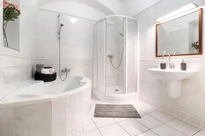 a white bathroom with a tub and a sink at 2 Bed Flat - Sleeps 6 - Pets - Wifi in Prague