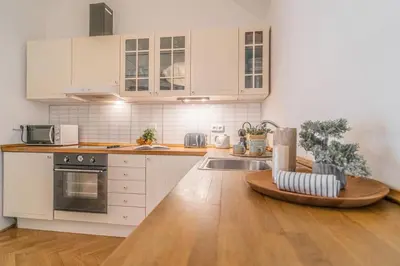 a kitchen with white cabinets and a wooden counter top at 2 Bed Flat - Sleeps 6 - Pets - Wifi in Prague