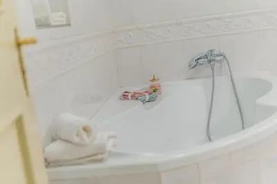 a white bathroom with a tub with a towel on it at 2 Bed Flat - Sleeps 6 - Pets - Wifi in Prague