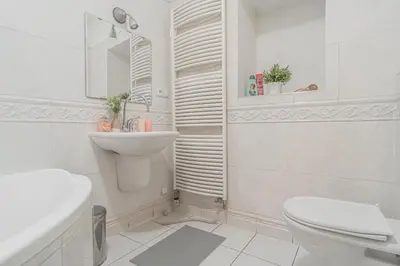 a white bathroom with a toilet and a sink at 1 Bed Flat - Sleeps 3 - Pets - Wifi in Prague