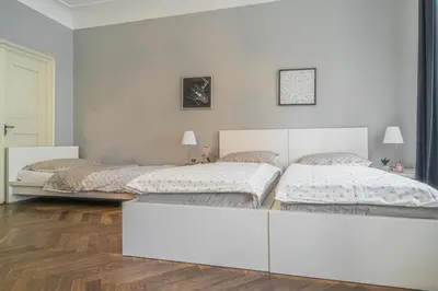 two beds in a room with white walls and wooden floors at 1 Bed Flat - Sleeps 3 - Pets - Wifi in Prague