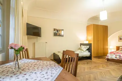 a room with two beds and a table with flowers on it at 1 Bed Flat - Sleeps 4 - Pets - Wifi in Prague