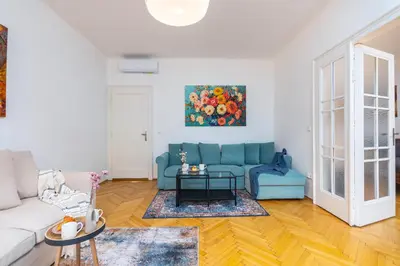 a living room with a blue couch and a table at Charles Bridge Historic Centre Elegant Spacious Apartment in Prague