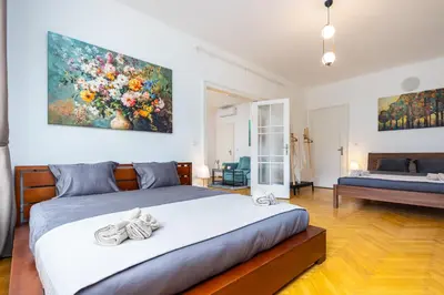 a bedroom with a bed and a painting on the wall at Charles Bridge Historic Centre Elegant Spacious Apartment in Prague