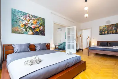 a bedroom with a bed and a painting on the wall at Charles Bridge Historic Centre Elegant Spacious Apartment in Prague