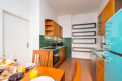 a kitchen with a wooden table with a dining room at Charles Bridge Historic Centre Elegant Spacious Apartment in Prague