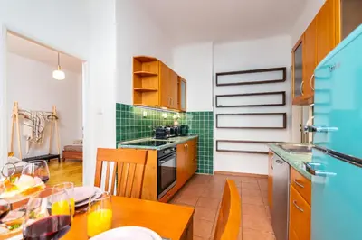 a kitchen with a wooden table and a kitchen with green tiles at Charles Bridge Historic Centre Elegant Spacious Apartment in Prague