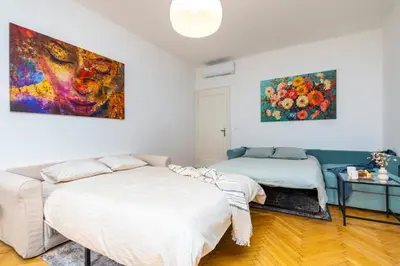 a bedroom with two beds and a painting on the wall at Charles Bridge Historic Centre Elegant Spacious Apartment in Prague