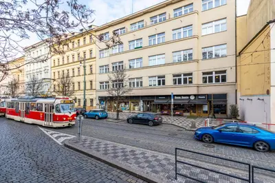 a red and white tram on a street in front of a building at Charles Bridge Historic Centre Elegant Spacious Apartment in Prague