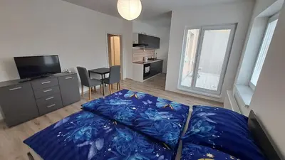 a living room with a bed and a flat screen tv at Apartmán u letiště in Tuchoměřice