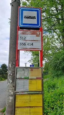 a sign on a pole next to a street at Apartmán u letiště in Tuchoměřice