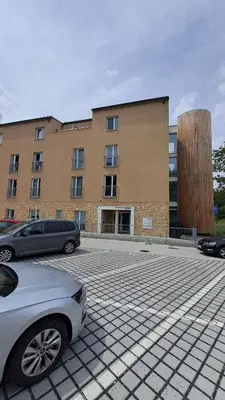 a parking lot with cars parked in front of a building at Apartmán u letiště in Tuchoměřice