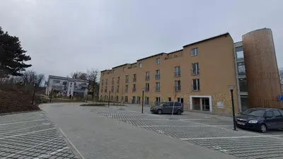 two cars parked in a parking lot next to a building at Apartmán u letiště in Tuchoměřice