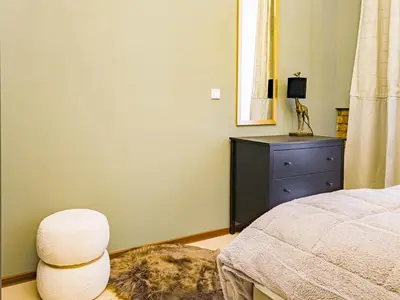 a bedroom with a bed and a chair and a dresser at Magnificent Apartment with Sauna and Billiards in Prague