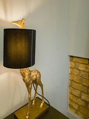 a gold giraffe lamp sitting on top of a table at Magnificent Apartment with Sauna and Billiards in Prague