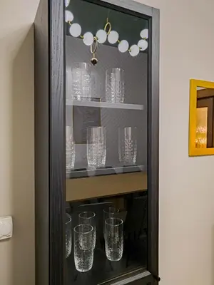 a glass cabinet with glasses in it at Magnificent Apartment with Sauna and Billiards in Prague