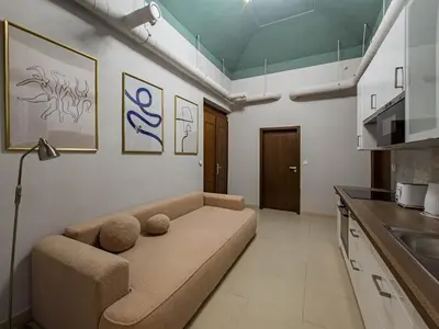 a living room with a couch in a kitchen at Magnificent Apartment with Sauna and Billiards in Prague