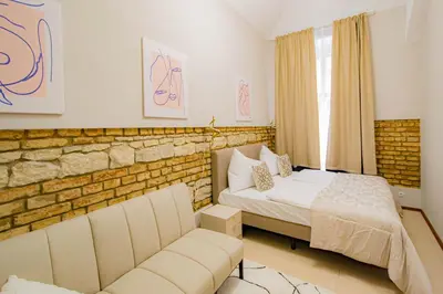 a bedroom with a bed and a couch and a window at Magnificent Apartment with Sauna and Billiards in Prague