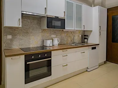 a kitchen with white cabinets and a stove top oven at Magnificent Apartment with Sauna and Billiards in Prague