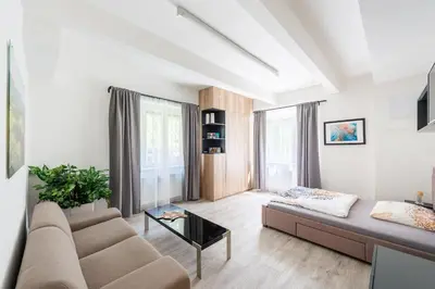 a living room with a couch and a table at Apartment by the metro with private parking in Prague