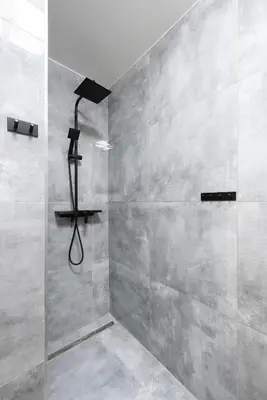 a bathroom with a shower with a glass door at Apartment by the metro with private parking in Prague