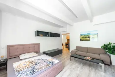 a bedroom with a bed and a couch at Apartment by the metro with private parking in Prague