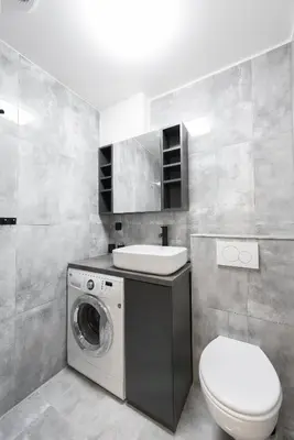 a bathroom with a washing machine and a sink at Apartment by the metro with private parking in Prague