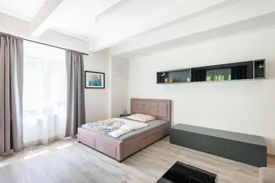 a bedroom with a bed and a large window at Apartment by the metro with private parking in Prague