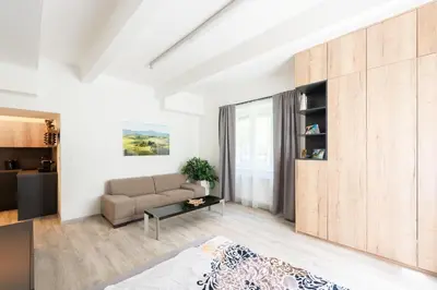 a living room with a couch and a table at Apartment by the metro with private parking in Prague
