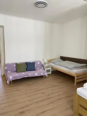 a living room with two beds and a purple couch at Apartment Ípák in Prague