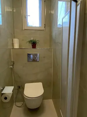a bathroom with a toilet and a window and a shower at Apartment Ípák in Prague