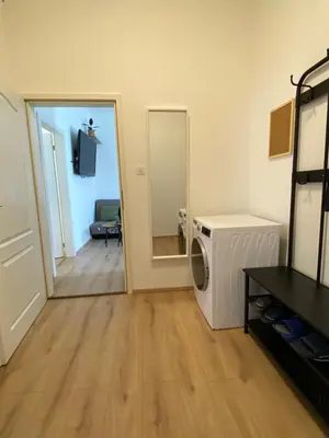 a laundry room with a washer and dryer and a mirror at Apartment Ípák in Prague