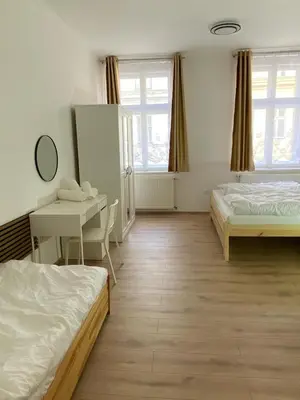 a bedroom with two beds and a table and a desk at Apartment Ípák in Prague