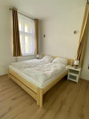 a large bed in a bedroom with a window at Apartment Ípák in Prague