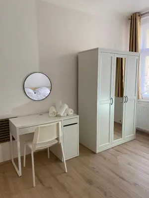 a white room with a desk and a mirror at Apartment Ípák in Prague