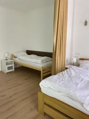 two beds in a room with wooden floors at Apartment Ípák in Prague