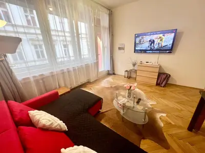 a living room with a red couch and a flat screen tv at Cozy private apartment in Prague