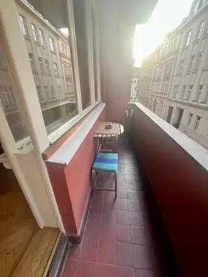 a table and a chair in a room with windows at Cozy private apartment in Prague