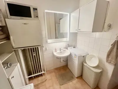 a small white bathroom with a sink and a toilet at Cozy private apartment in Prague