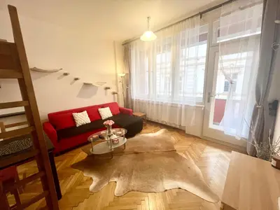 a living room with a red couch and a large window at Cozy private apartment in Prague