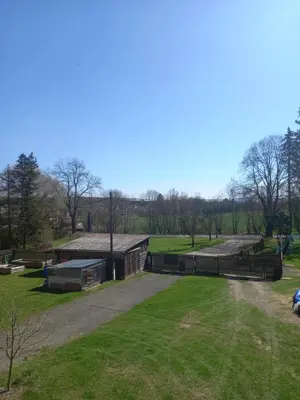 a building with a fence and a grass field at U Dobroty in Nový Dŭm