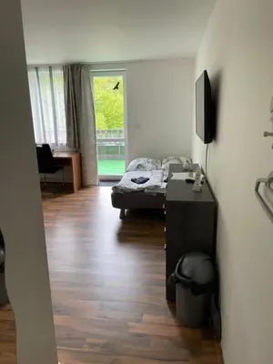 a room with a bed and a desk and a television at Marina Hubenov in Hubenov