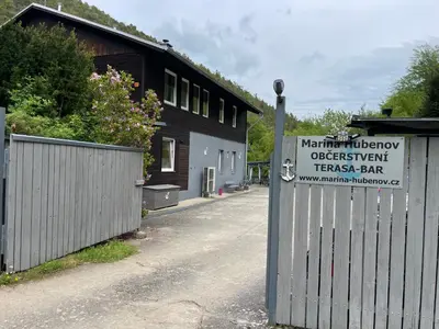 a sign on a fence in front of a building at Marina Hubenov in Hubenov