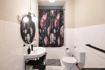 a bathroom with a sink and a toilet and a shower curtain at Old Town Astronomical Clock Cathedral View Balcony in Prague