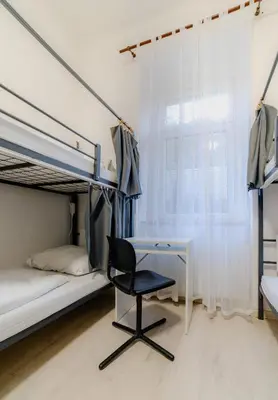 a desk and a chair in a room with bunk beds at Hostel Karlin in Prague