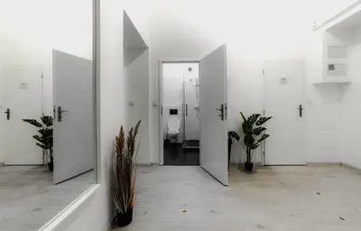 a bathroom with white walls and a toilet with stalls at Hostel Karlin in Prague