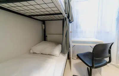 a bed and a chair in a small room at Hostel Karlin in Prague